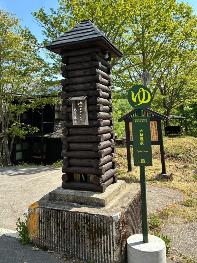 乳頭温泉郷 大釜温泉の湯めぐり号バス停看板と丸太風のモニュメント