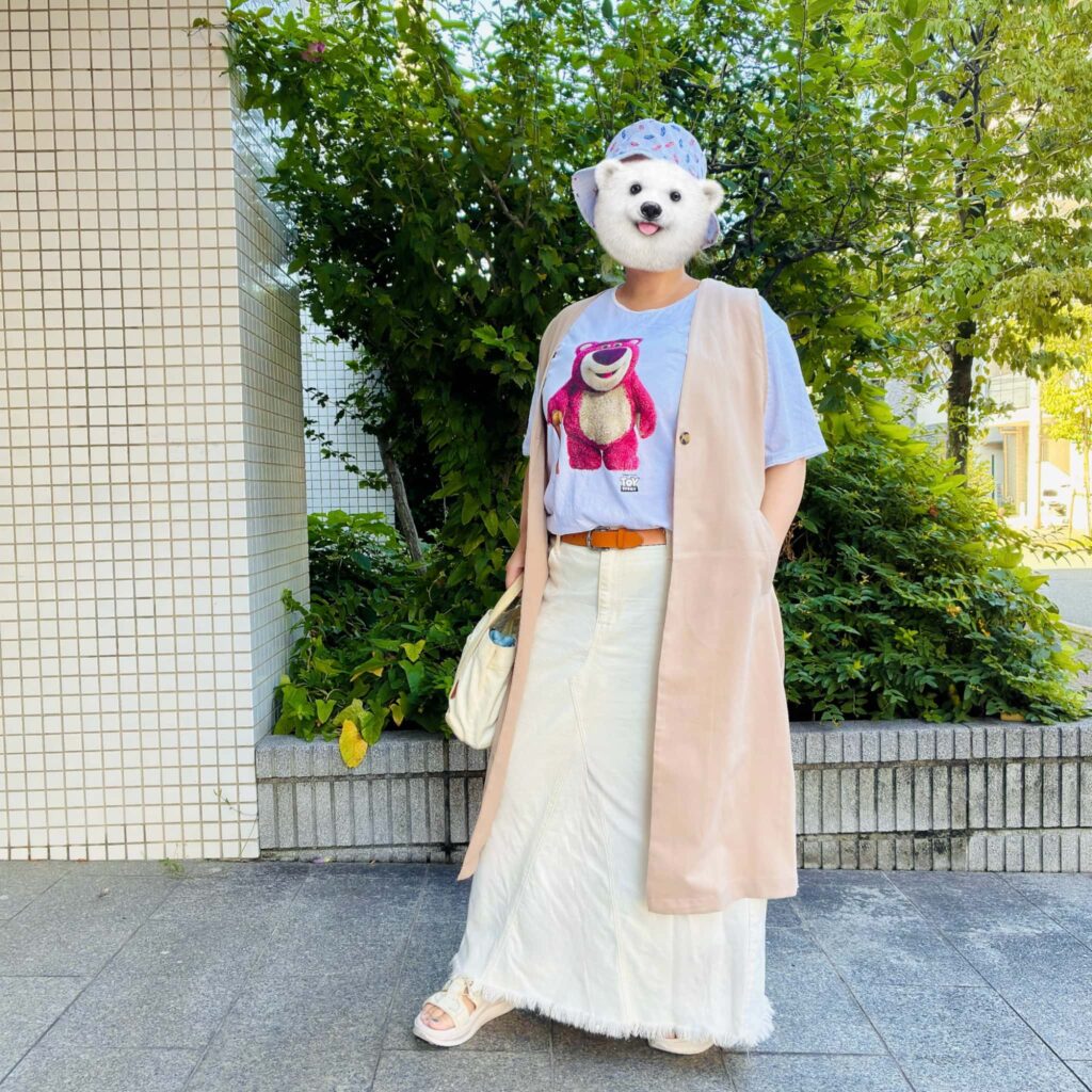 ロッツォのキャラクターTシャツに白デニムのロングスカートとベージュのジレを合わせた「トイストーリー」映画館コーデ