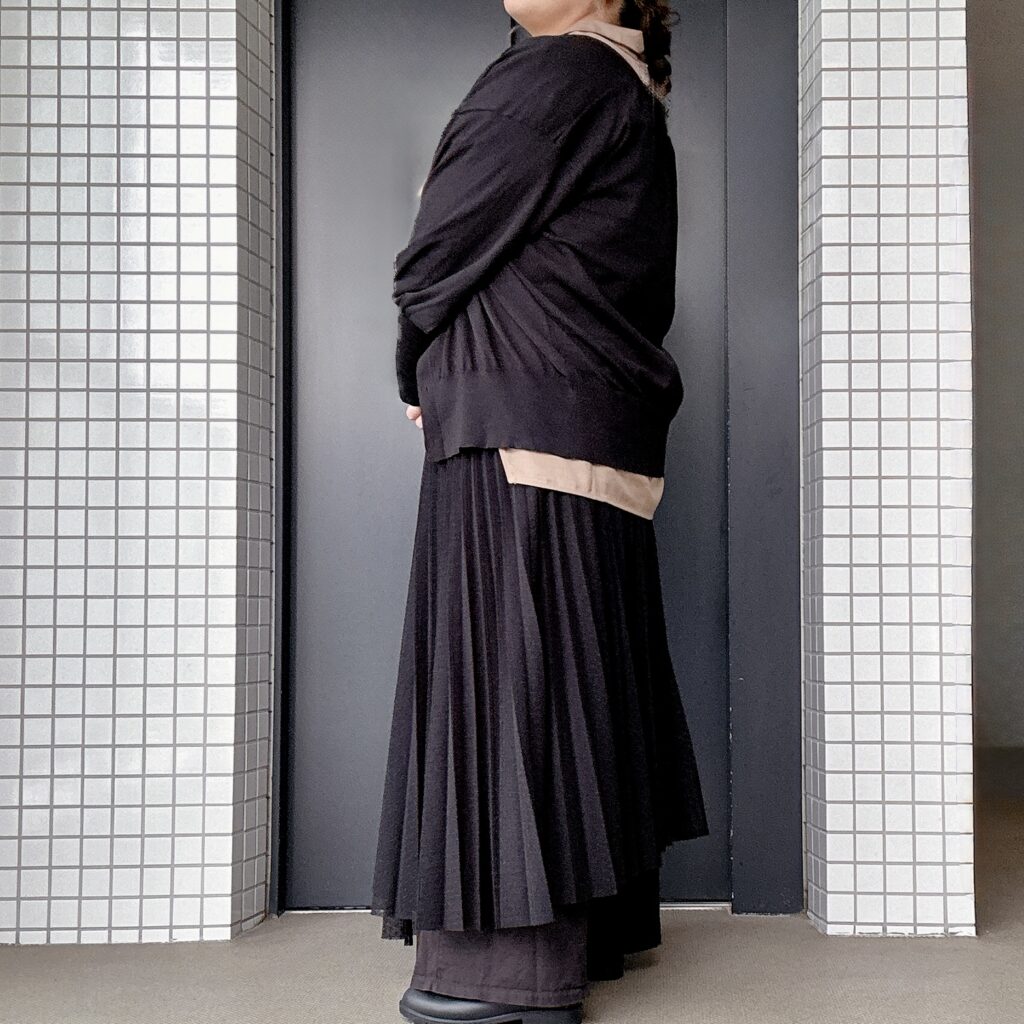 黒のロングカーディガンを羽織った秋のレイヤードコーディネートの横シルエット