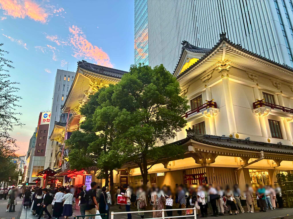 夕暮れ時の空と高層ビルを背景に美しくライトアップされた歌舞伎座の外観